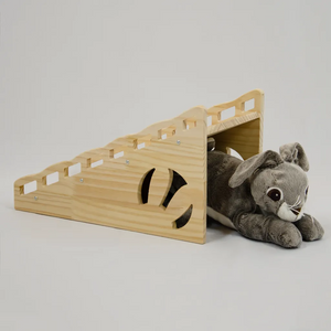rabbit laying under a wooden castle ramp