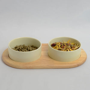 Two beige bowls on a flat bamboo stand