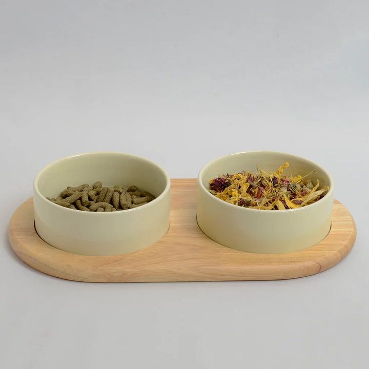 Two beige bowls on a flat bamboo stand