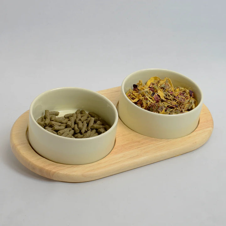 Two beige bowls for rabbits on a inclined bamboo stand