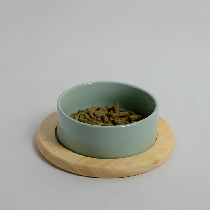 One light green bowl for rabbits on a inclined bamboo stand