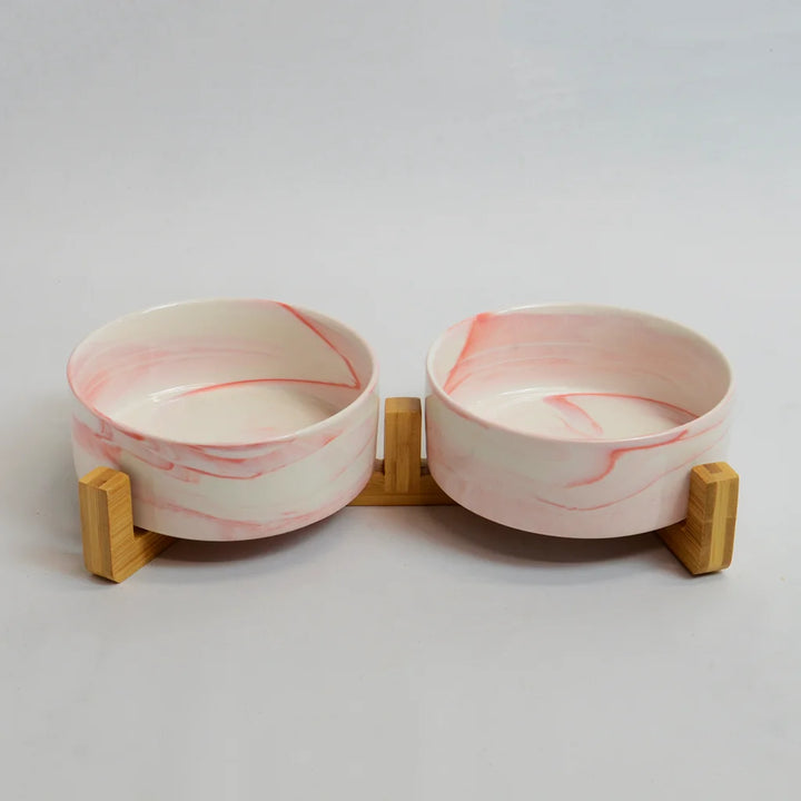 Two pink marble-look bowls on a raised bamboo stand