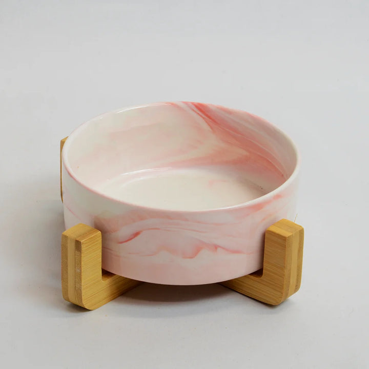 One pink marble-look bowls on a raised bamboo stand