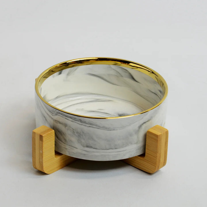 One grey marble-look bowl with gold rim on a raised bamboo stand